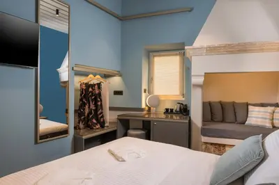 a bedroom with a bed and a desk with a mirror at Veneri Boutique Suites in Chania Town