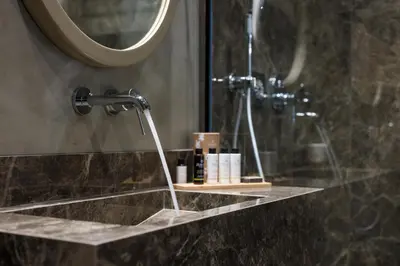 a bathroom with a sink with a shower and a mirror at Veneri Boutique Suites in Chania Town