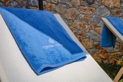 a blue towel sitting on top of a chair at Cypress Village - Lux villa 5' from beach in Daratso