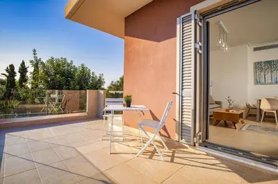 a patio with a table and chairs on a balcony at Cypress Village - Lux villa 5' from beach in Daratso