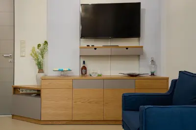 a living room with a tv on top of a cabinet at Cypress Village - Lux villa 5' from beach in Daratso
