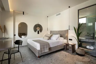 a bedroom with a bed and a sink and a mirror at Casa Nostos in Agia Marina Nea Kydonias