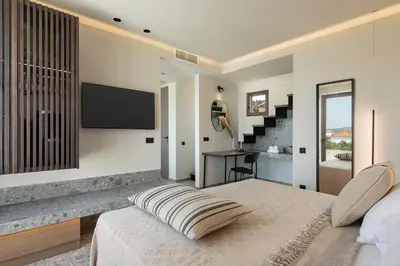 a bedroom with a bed and a tv on a wall at Casa Nostos in Agia Marina Nea Kydonias