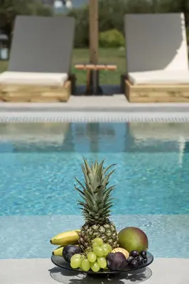 a plate of fruit on a table next to a pool at Casa Nostos in Agia Marina Nea Kydonias