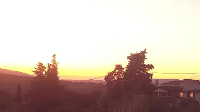 a sunset over a city with trees and houses at γαληνη in Vamos