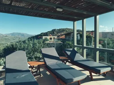 a group of chairs on a balcony with a view at King Crimson Luxury Apartments in Marathokefála