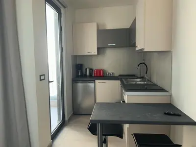 a small kitchen with white cabinets and a counter top at King Crimson Luxury Apartments in Marathokefála