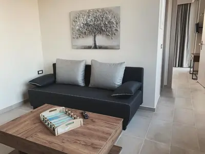 a living room with a black couch and a table at King Crimson Luxury Apartments in Marathokefála