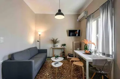 a living room with a blue couch and a table at EMMANUEL’S COZY HOUSE in Chania Town