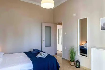 a bedroom with a bed with a blue blanket at EMMANUEL’S COZY HOUSE in Chania Town