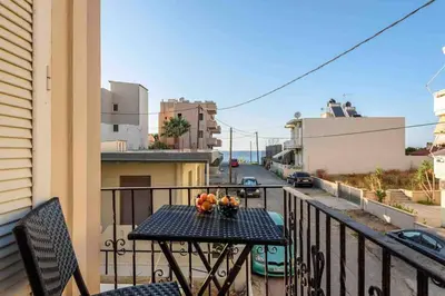 a table on a balcony with a view of a street at EMMANUEL’S COZY HOUSE in Chania Town