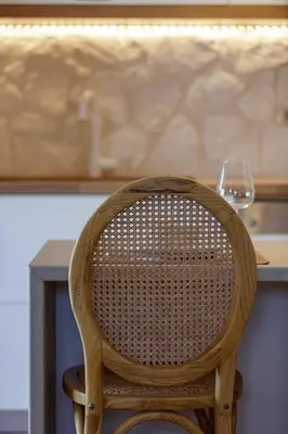 a wooden chair sitting in front of a table at Villa Seashell -Wonderful newly renovated villa on the beach in Galatás
