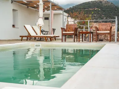a swimming pool with chairs and a table at Kampos View - Quiet House at the end of the Road, private pool in Kámbos
