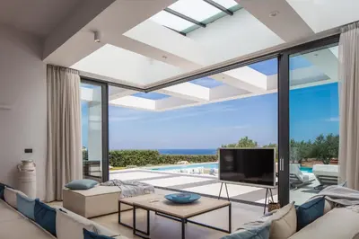 a living room with a couch and a tv at Chic Dream Villa in Agios Onoufrios