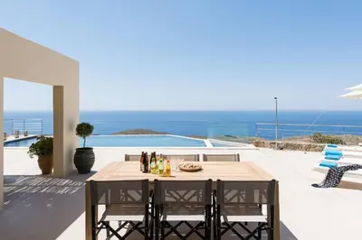 a table and chairs on a patio with a view of the ocean at Villa Thetis Sfakia in Sfakiá