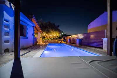 a swimming pool in a backyard at night at Villa Tzitzifes in Tzitzifés