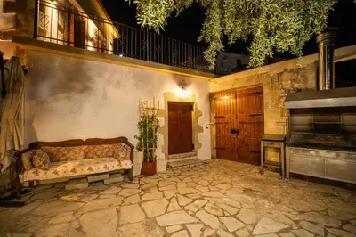 a couch sitting on a stone patio with a piano at Villa Tzitzifes in Tzitzifés