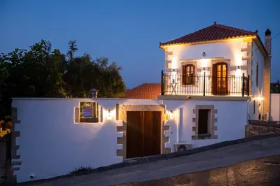 a white house with a balcony on top of it at Villa Tzitzifes in Tzitzifés