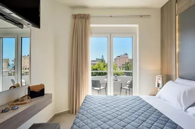 a bedroom with a bed and a balcony with a table at Elia Residences in Chania Town