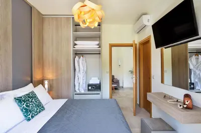 a bedroom with a bed and a flat screen tv at Elia Residences in Chania Town
