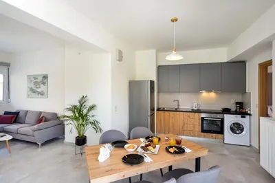 a kitchen and a living room with a wooden table at Elia Residences in Chania Town