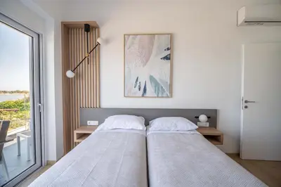 a bedroom with two beds and a window at Isalos Seafront Villa I Sea fragrance in Chania Town