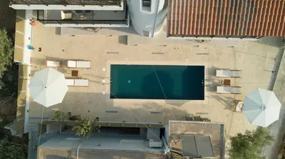an overhead view of a swimming pool with two umbrellas at Hello Village Chania in SFakianalíon