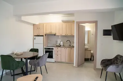 a kitchen and dining room with a table and chairs at Hello Village Chania in SFakianalíon