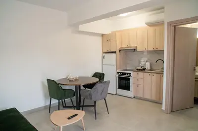 a kitchen with a table and chairs in a room at Hello Village Chania in SFakianalíon