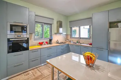 a kitchen with blue cabinets and a table at Anemomili Villas in Drapaniás