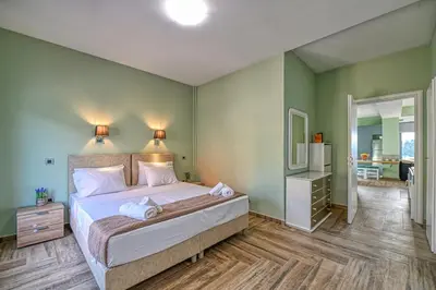 a bedroom with a king sized bed and a bathroom at Anemomili Villas in Drapaniás