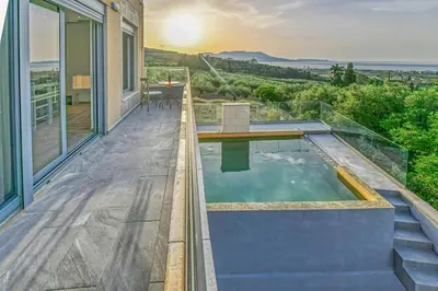 a house with a plunge pool on a balcony with a view at Anemomili Villas in Drapaniás