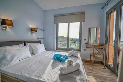 a bedroom with a bed with towels on it at Anemomili Villas in Drapaniás