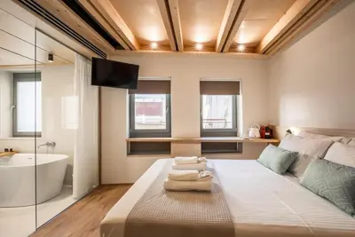 a bedroom with a bed and a tub and a sink at Thallos The Boutique in Chania Town