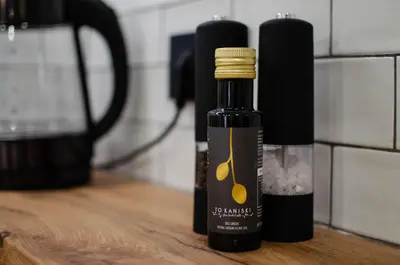 a bottle of olive oil sitting on a wooden table at Marilias Luxury Studio Apartment in Kissamos