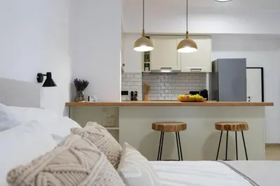 a kitchen with a counter and two stools in a room at Marilias Luxury Studio Apartment in Kissamos