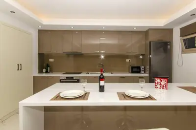a kitchen with two plates and a bottle of wine on a counter at Mare Monte Luxury Apartment in Kissamos