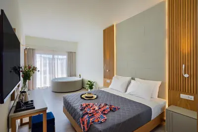 a hotel room with a bed and a bath tub at Elia Platanias in Plataniás
