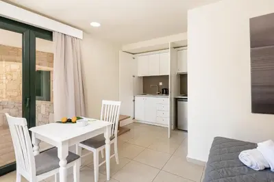 a kitchen and living room with a table and chairs at Elia Platanias in Plataniás
