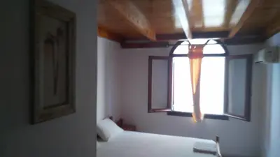 a room with a window and a white bed at Spamandos Rooms in Palaiochóra