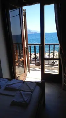 a bedroom with a view of the ocean from a balcony at Spamandos Rooms in Palaiochóra