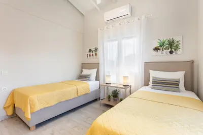 a bedroom with two beds and a window at Marika's Penthouse Chania in Chania Town