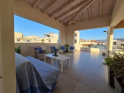 a bedroom with a bed and a table on a balcony at Marika's Penthouse Chania in Chania Town