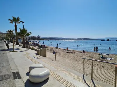 a beach with people on the sand and the water at Marika's Penthouse Chania in Chania Town
