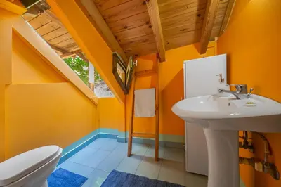 a bathroom with orange walls and a sink and a toilet at Hani Kastania - Chania retreat for families and groups for holidays and workshops in Sémbronas