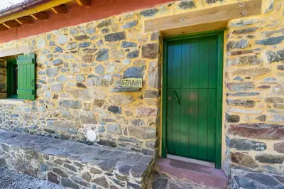 a green door on the side of a stone building at Hani Kastania - Chania retreat for families and groups for holidays and workshops in Sémbronas
