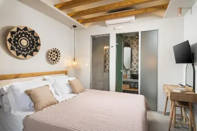 a bedroom with a bed and a desk and a television at Villas Plumeria in Palaiochóra