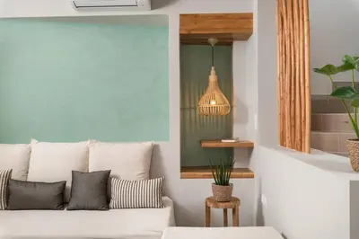 a living room with a white couch and a pendant light at Villas Plumeria in Palaiochóra