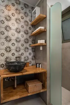 a bathroom with a bowl sink and a wall at Villas Plumeria in Palaiochóra
