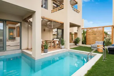 a house with a swimming pool and a patio at Villas Plumeria in Palaiochóra